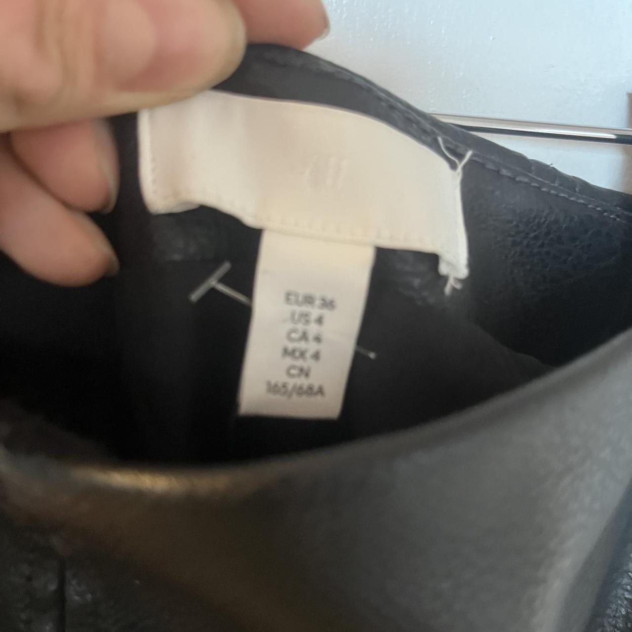 Black faux leather mini skirt with zipper and buckle detail